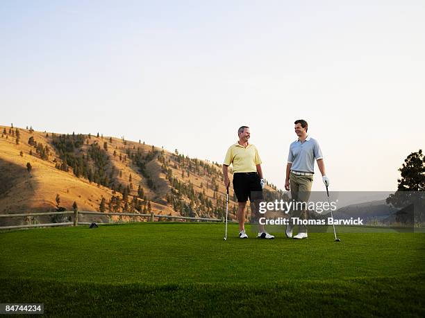 father and son on golf course, laughing - usa golf stock-fotos und bilder