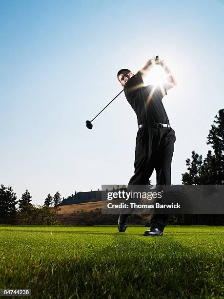 male golfer hitting tee shot - abschlagen stock-fotos und bilder