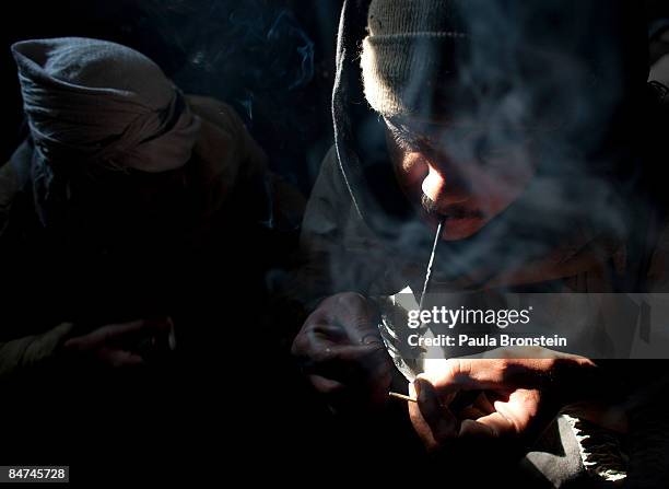 An addict smokes heroin inside the abandoned Russian Cultural center used as the heroin gathering point in the captiol city February 08, 2009 in...