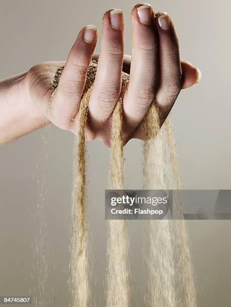 sand slipping through fingers - zand stockfoto's en -beelden