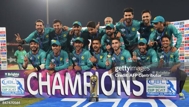 Pakistani cricketers pose for a photograph with trophy after winning the third and final Twenty20 International match against World XI at the Gaddafi...