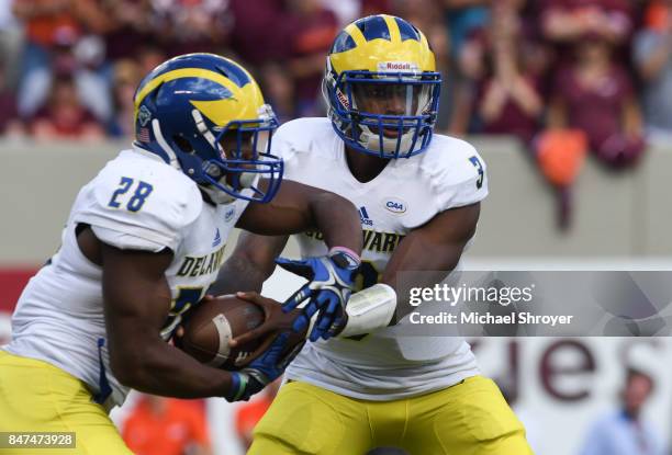 Quarterback Joe Walker of the Delaware Fightin Blue Hens hands the ball to running back Thomas Jefferson in the first half against the Virginia Tech...