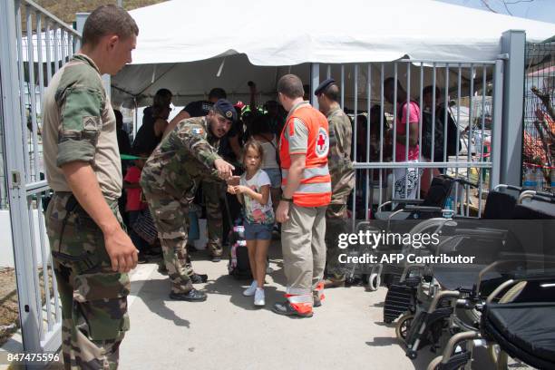 Miltary and Red Cros staff show a girl the way during an evacuation to Guadeloupe island at the Grand Case l'Esperance airport on the French...