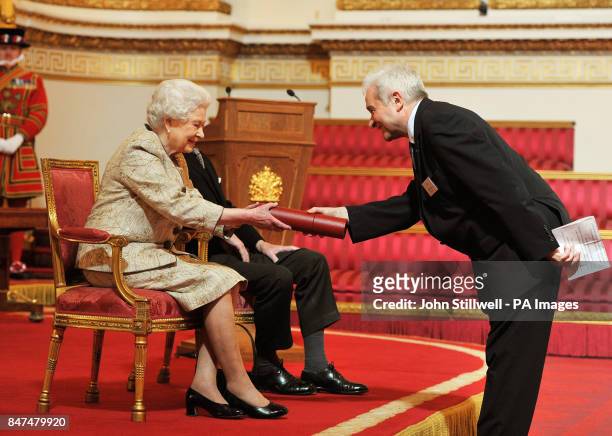 Queen Elizabeth II accompanied by the Duke of Edinburgh receives a copy of the loyal address from the Royal Society President Sir Paul Nurse, during...