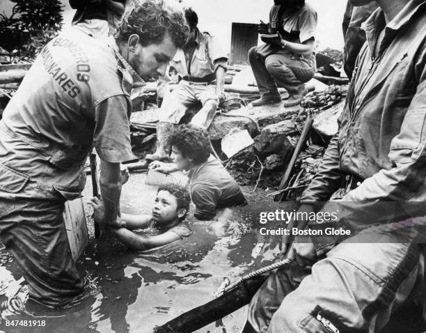 Men attempt to rescue Omaira Sanchez who is trapped in debris from the eruption of Nevado del Ruiz Volcano in Armero, Columbia on Nov. 15, 1985. She...