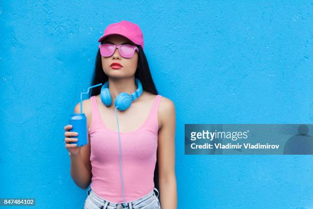 frau in rosa outfit blauen halten können - blauer hut stock-fotos und bilder