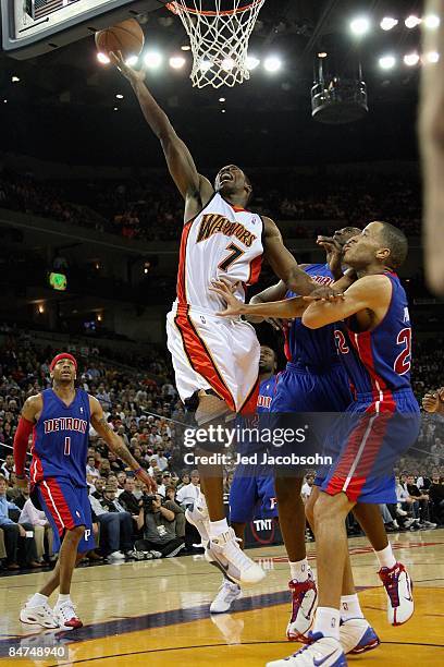 Kelenna Azubuike of the Golden State Warriors lays the ball up over Allen Iverson, Jason Maxiell and Tayshaun Prince of the Detroit Pistons during...