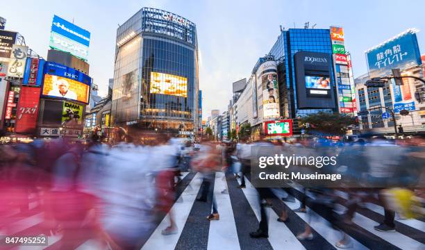 pedestrians crossing the street at shibuya crossing with motion blur - shibuya ward stock pictures, royalty-free photos & images