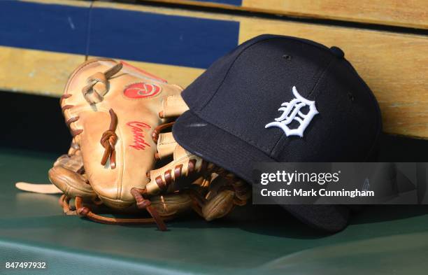 Detailed view of the baseball glove and hat used by Jeimer Candelario of the Detroit Tigers sitting in the dugout during the game against the Kansas...