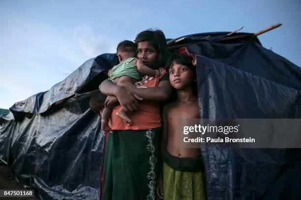 Rohingya family stands by their makeshift tent at a new IDP camp on September 15, 2017 in Tankhali, Bangladesh. Nearly 400,000 Rohingya refugees have...