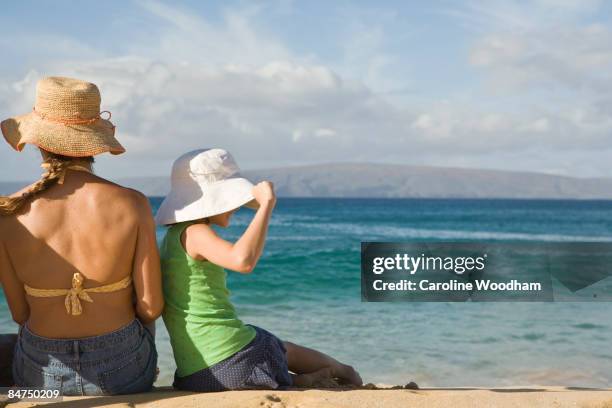 mother and daughter sitting on the beach - makena maui stock pictures, royalty-free photos & images