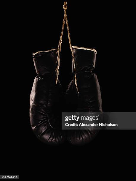 old black boxing gloves on black background - boxing gloves foto e immagini stock