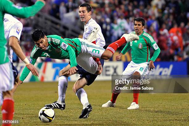 Carlos Salcido of Mexico goes airborne after being upended by Sacha Kljestan of Team USA during their FIFA World Cup qualifying match on February 11,...
