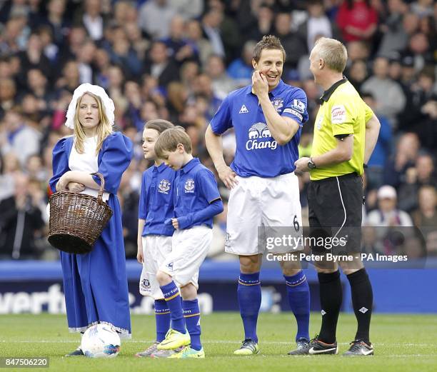 The Everton toffee lady stands with Everton's Phil Jagielka and match referee Peter Walton