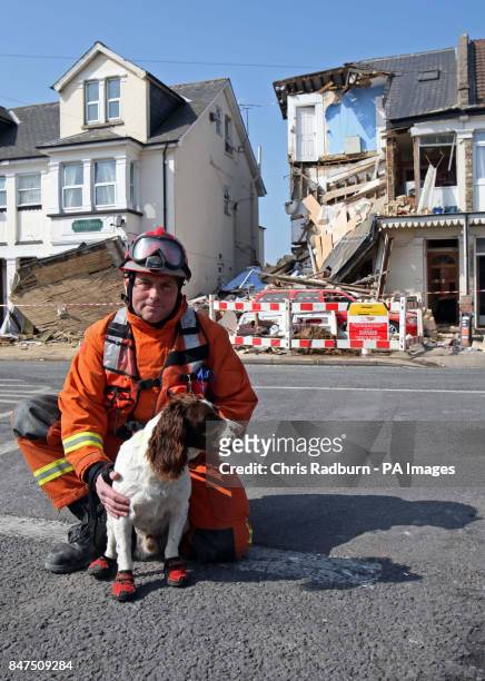 Fire and Rescue worker Graham Currie with sniffer dog Kirby, who discovered a casualty buried in the rubble at a house, divided into three flats, in...
