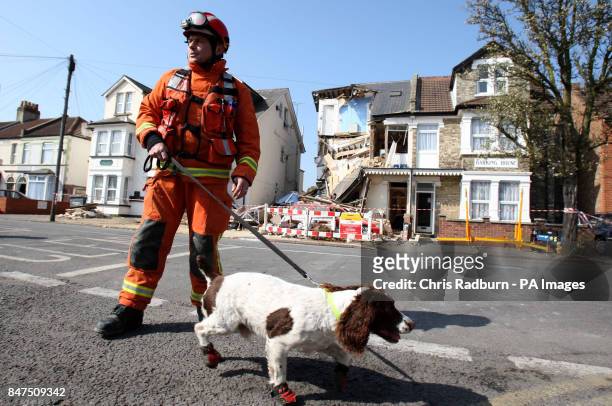 Fire and Rescue worker Graham Currie with sniffer dog Kirby, who discovered a casualty buried in the rubble at a house, divided into three flats, in...