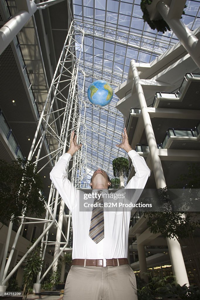 Businessman playing with earth globe