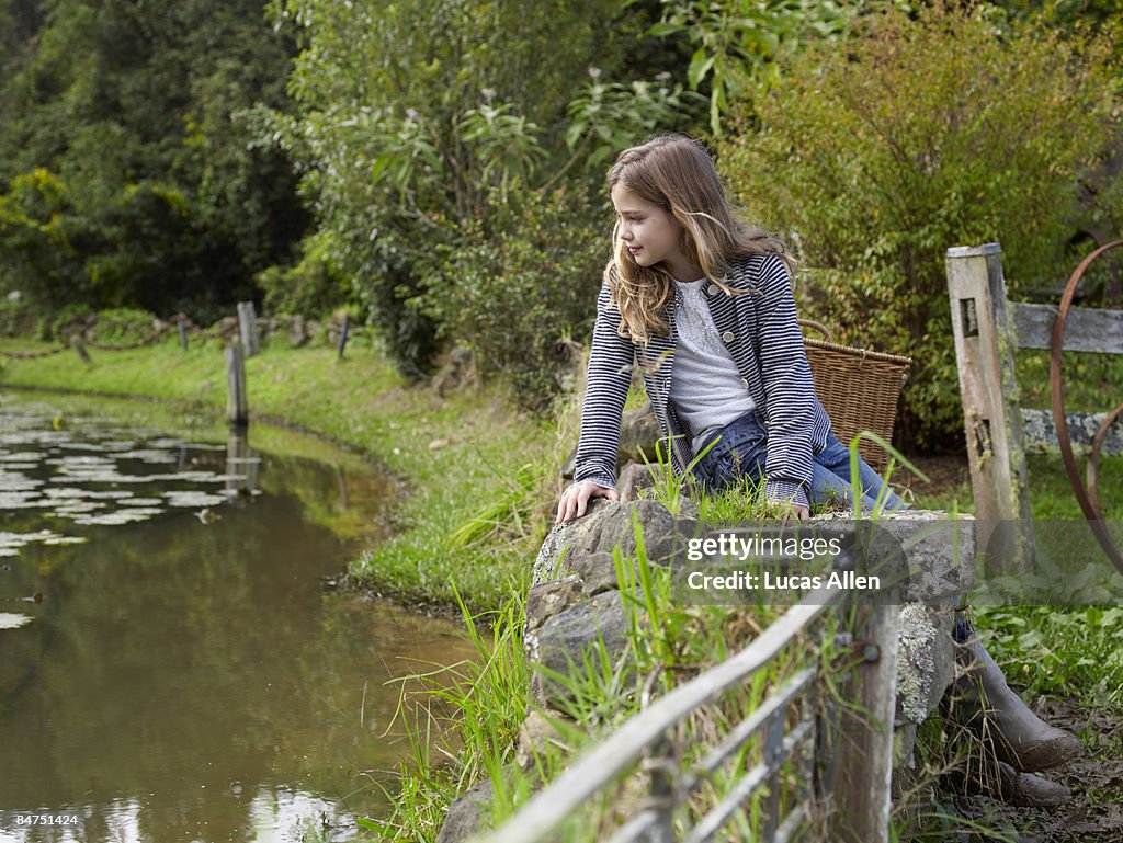 Girl looking into country pond