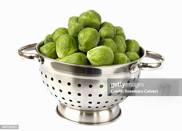collander filled with brussel sprouts. - brussel sprout stock pictures, royalty-free photos & images
