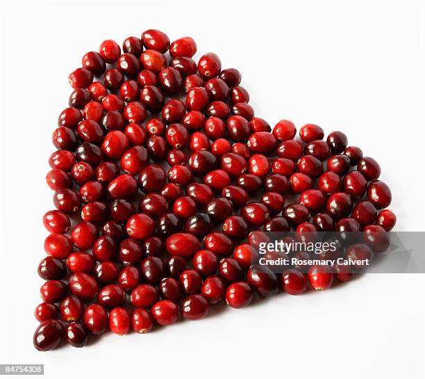 ripe cranberries arranged in heart shape. - cranberry heart stock-fotos und bilder