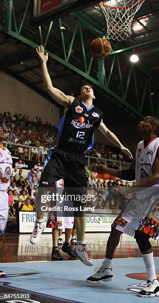 Adam Tanner of the Breakers shoots for goal as Darnell Mee of the Taipans looks on during the round 22 NBL match between the New Zealand Taipans and...