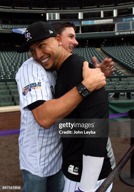 Colorado Rockies right fielder Carlos Gonzalez gets a hug from former player Brad Hawpe during batting practice before the game with the San Diego...