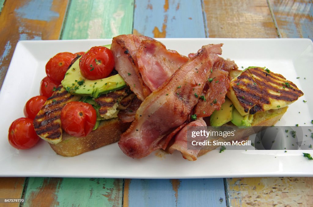 Fried bacon, grilled halloumi cheese, raw avocado and roasted cherry tomatoes served on toasted soughdough bread