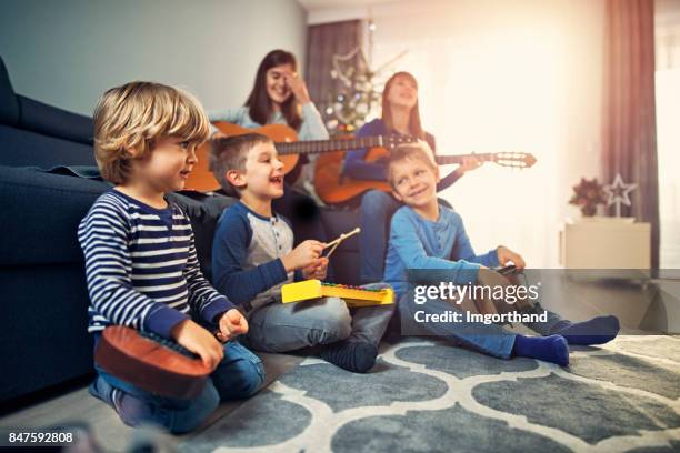 group of kids practicing christmas carols - christmas orchestra stock pictures, royalty-free photos & images