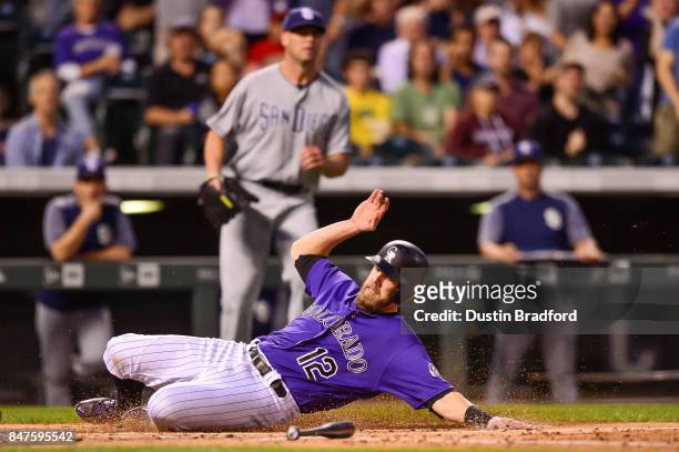 Mark Reynolds of the Colorado Rockies slides past home plate as he scores a run against the San Diego Padres int he second inning of a game at Coors...