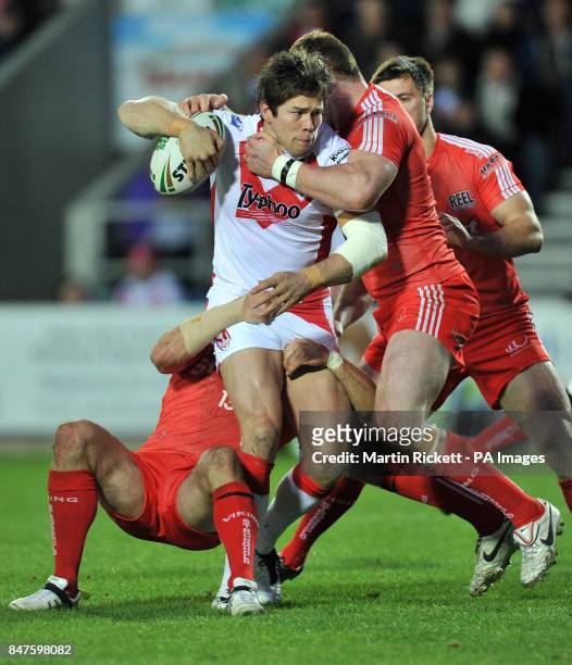 St Helens Louie McCarthy-Scarsbrook is tackled by Widnes' Jon Clarke and Anthony Mullally during the Stobart Super League match at Langtree Park, St...