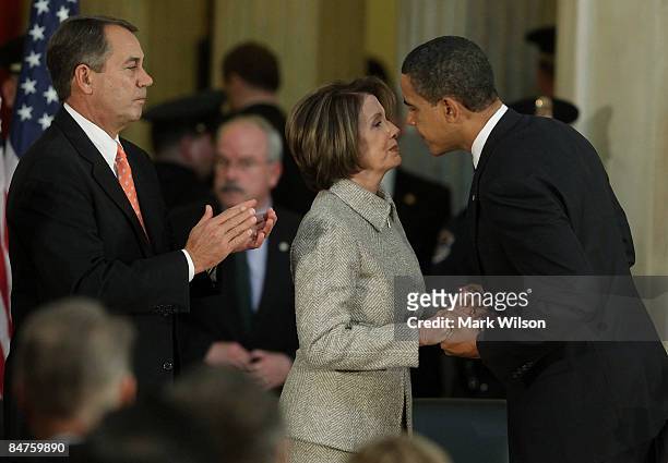 President Barack Obama shakes hands with House Speaker Nancy Pelosi while House Republican Leader John Boehner stands nearby during a ceremony in the...
