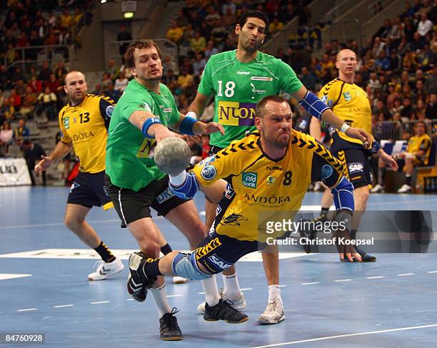 Christian Schwarzer of the Rhein Neckar Loewen throws a goal and Michal Kubisztal of the Fuechse Berlin and Hany El Fakharany of the Fuechse Berlin...