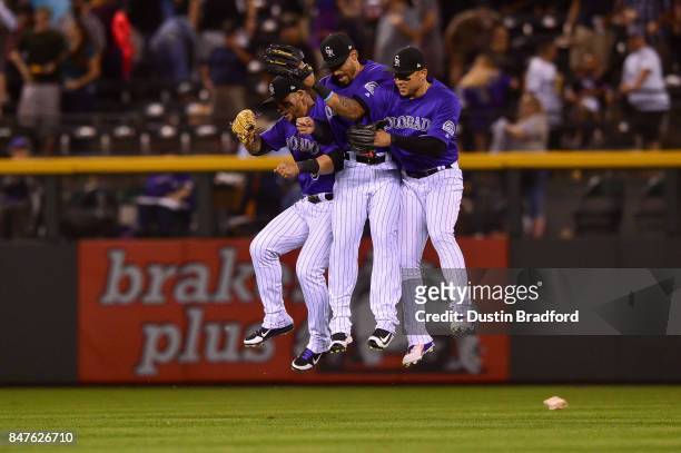 Colorado Rockies outfielders, from left, Gerardo Parra, Ian Desmond, and Carlos Gonzalez celebrate after a 6-1 win over the San Diego Padres at Coors...