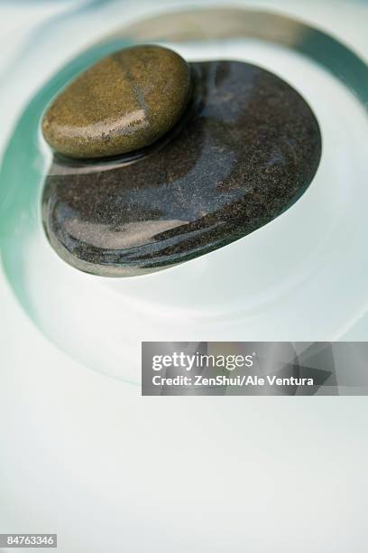 two stones stacked one on the other, partially submerged in water - natale stockfoto's en -beelden