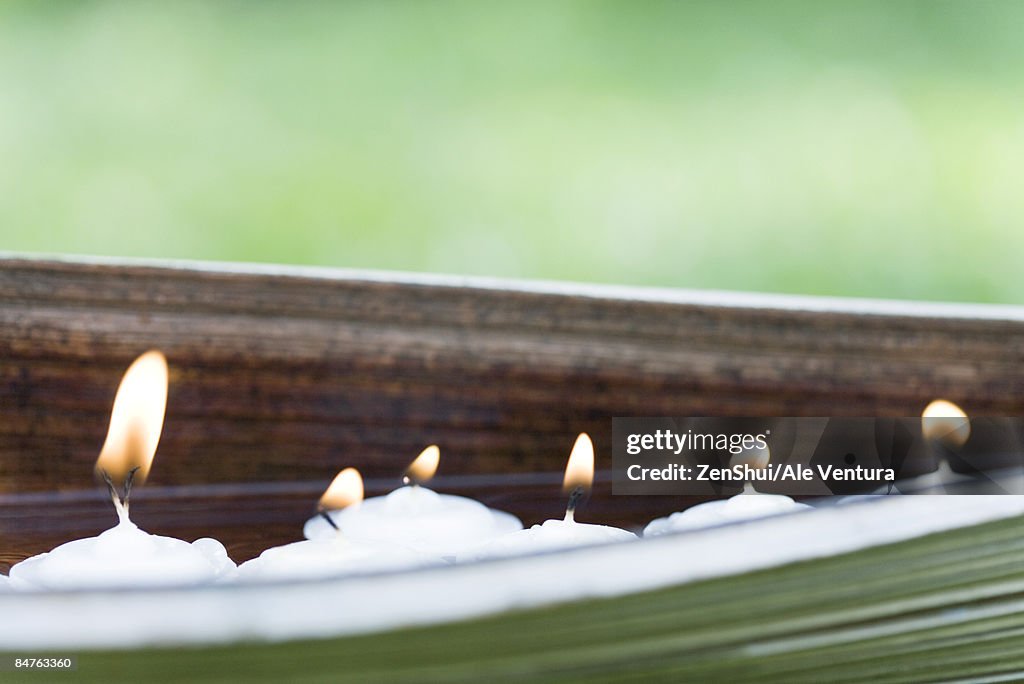 Lit votive candles in natural setting