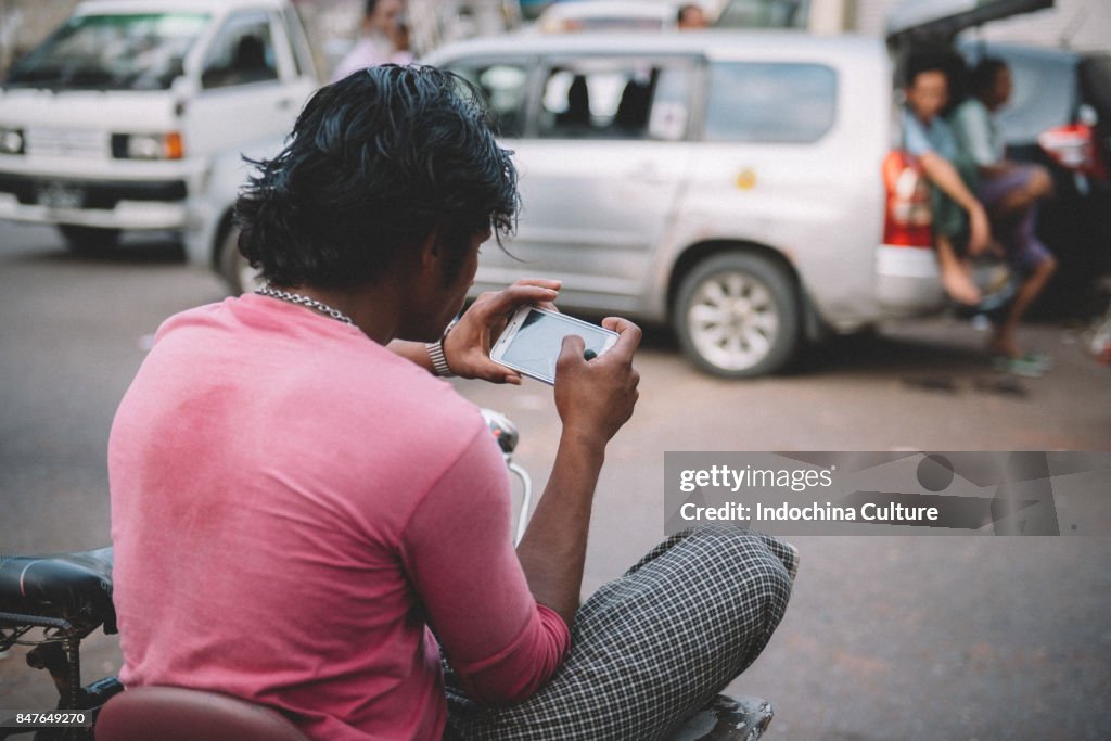 Man (Burmese using phone -rear view)