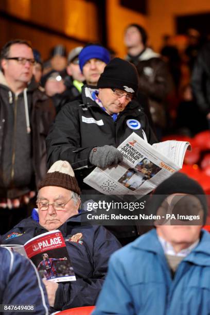 Fan reads the paper in the stands before the match