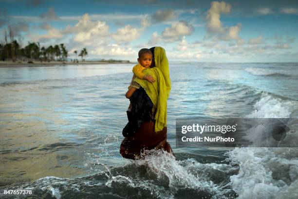 Myanmar Rohingya refugee woman hold her son seen after arriving on a boat to Bangladesh on Shah Porir Dip Island Teknaf, Bangladesh 14 September...