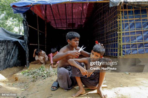 Rohingya young boy cuts the mautache of a man at the Kutupalong camp in Ukhiya, Bangladesh 15 September 2017. Many of the Rohingya fleeing the...