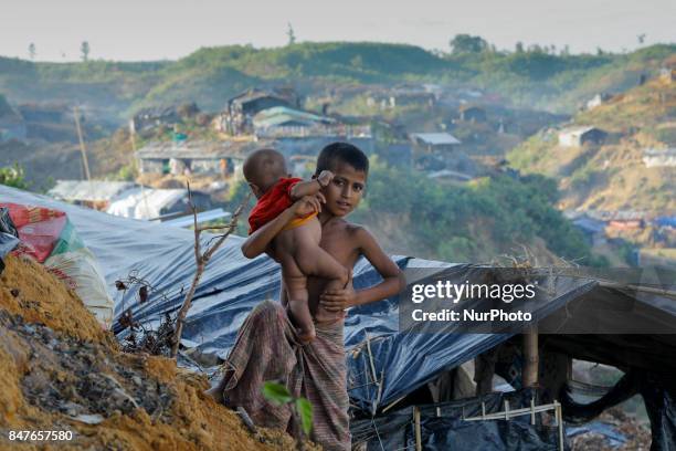 Rohingya boy with his brother stands close to her makeshift tent at the Balukhali camp in Ukhiya, Bangladesh 15 September 2017. Many of the Rohingya...