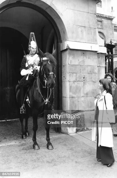 Mireille Mathieu regardant un horse guard a Whitehall durant son sejour dans la capitale britannique en mai 1974 a Londres, Royaume-Uni.