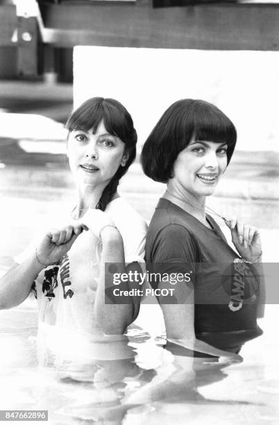 Mireille Mathieu et sa soeur Monique se detendent dans la piscine lors de leur sejour dans la petite cite provencale en aout 1980 a La Bedoule,...