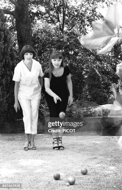 Mireille Mathieu se detend dans la propriete de son impresario Johnny Stark pres de Marseille et joue a la petanque avec sa soeur Monique en aout...