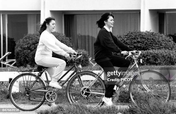 Mireille Mathieu fait de la bicyclette avec sa soeur Monique pendant son sejour dans la station bretonne en janvier 1981 a Quiberon, France.