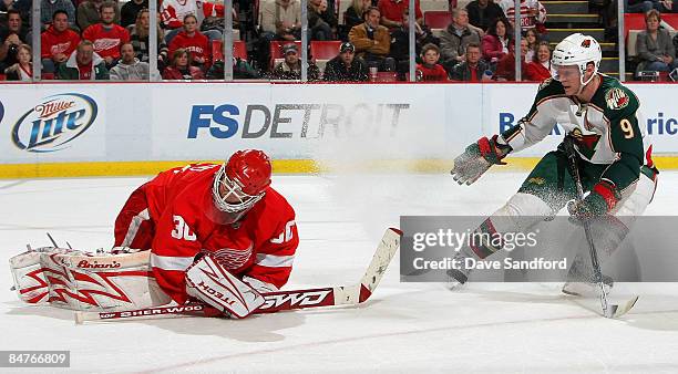 Mikko Koivu of the Minnesota Wild sprays Chris Osgood of the Detroit Red Wings with ice during their NHL game at Joe Louis Arena February 12, 2009 in...