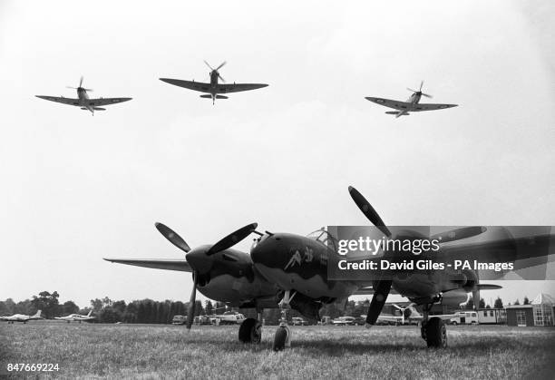 Three Spitfires fly over 'Miss Behaving', a Lockheed P38 Lightning. These vintage aircraft of World War Two are on display at the Biggin Hill...