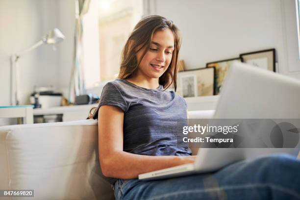 joven adolescente dedicando el tiempo libre en casa. - teen computer fotografías e imágenes de stock