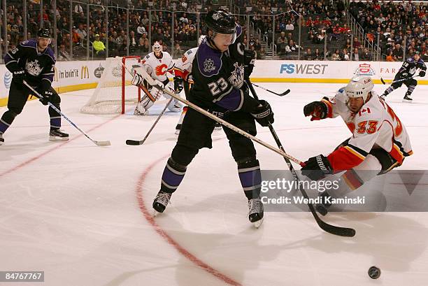 Dustin Brown of the Los Angeles Kings passes the puck against Adrian Aucoin of the Calgary Flames on February 12, 2009 at Staples Center in Los...