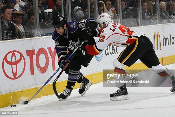 Jarret Stoll of the Los Angeles Kings skates after a loose puck against Daymond Langkow of the Calgary Flames on February 12, 2009 at Staples Center...