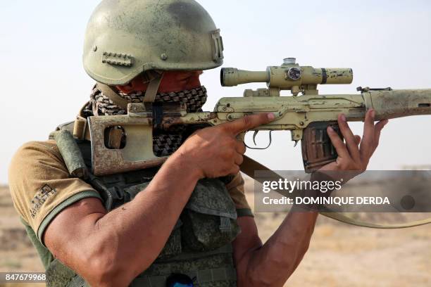 Picture taken during a press tour provided by the Russian Armed Forces on September 15, 2017 shows a Russian soldier looking through the scope of a...